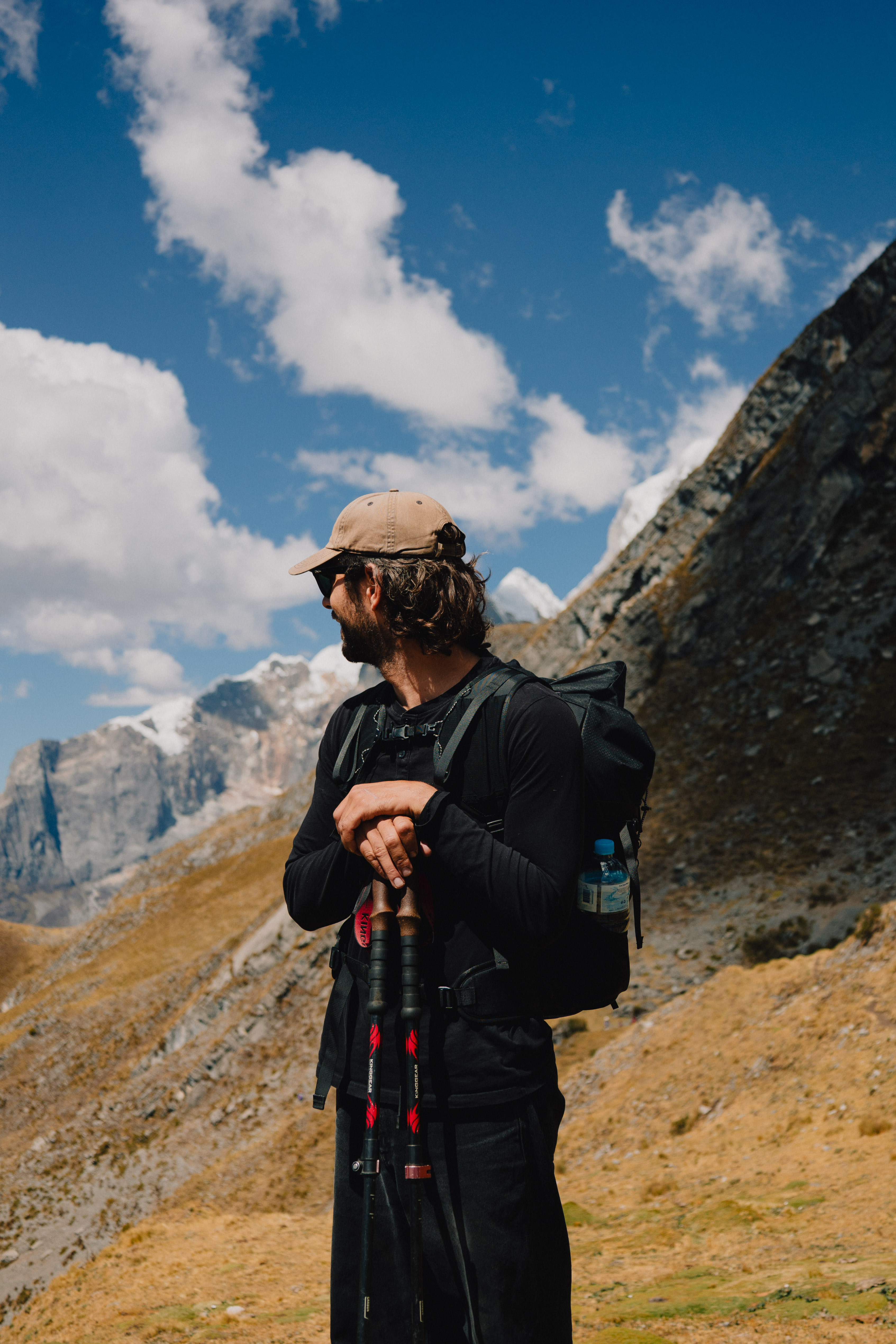Huayhuash – Luca mit Kappe, Sonnenbrille und Trekkingstöcken in den Bergen