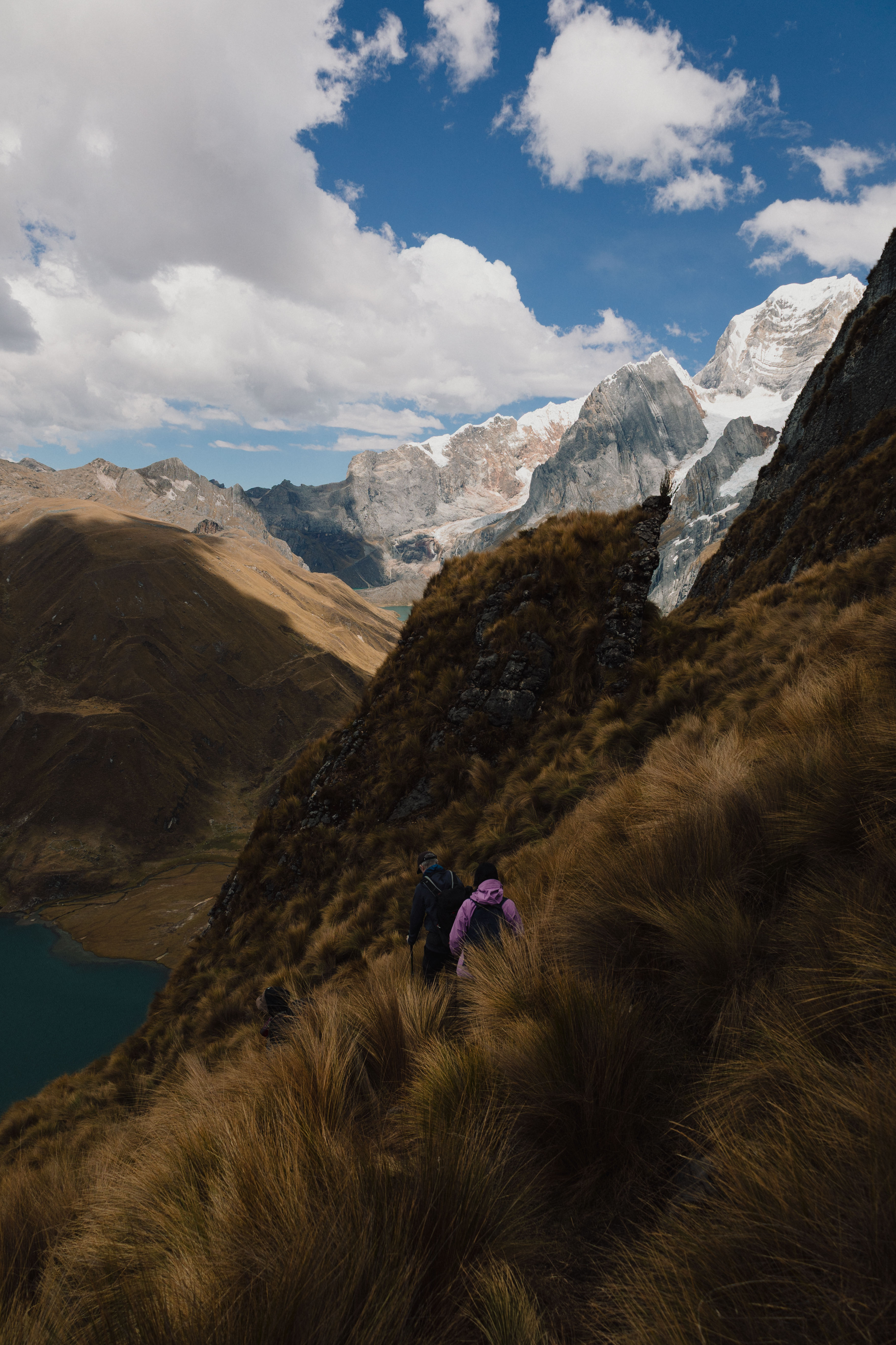 Huayhuash – einzelne Wanderin auf einem schmalen Pfad über einem türkisen See
