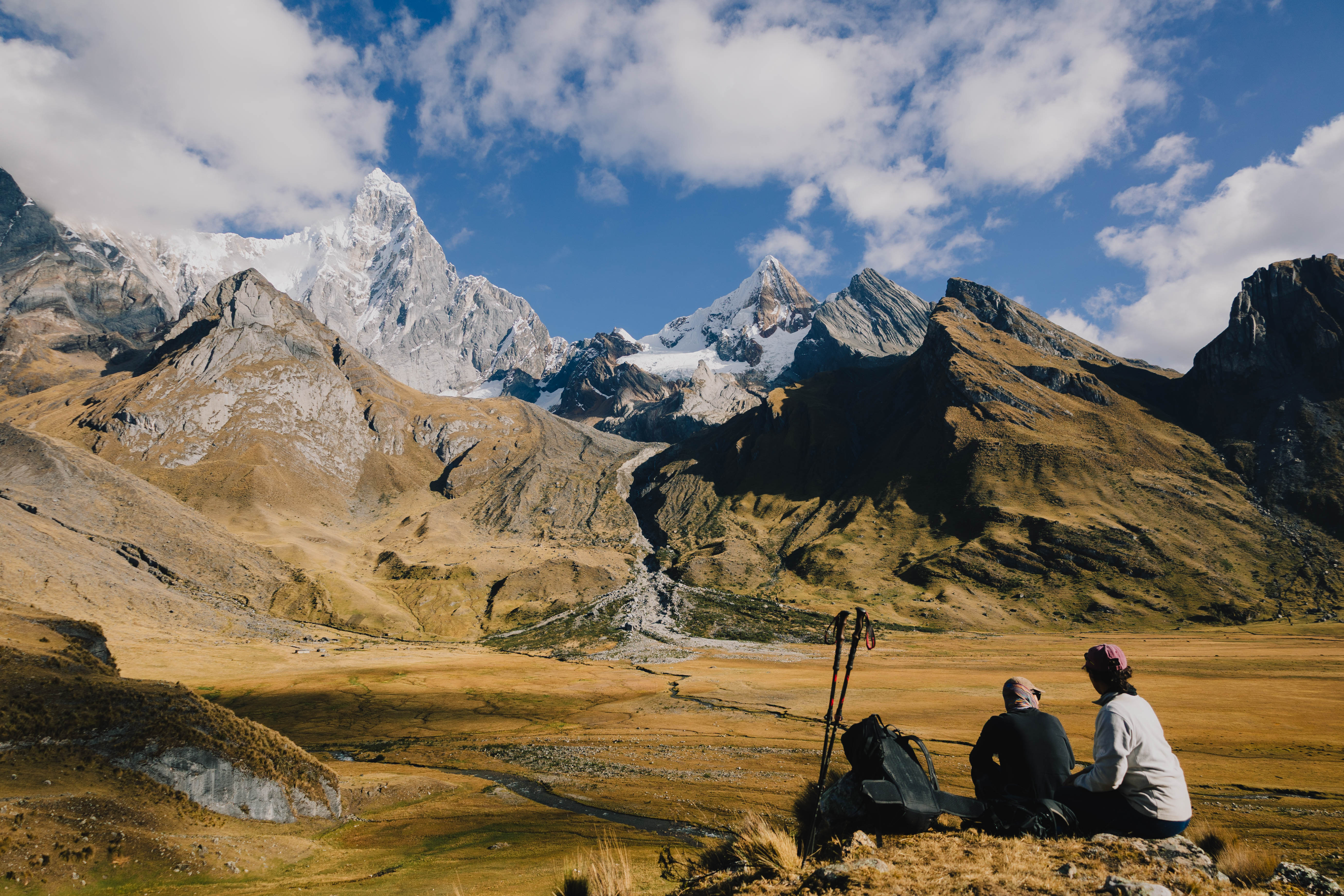 Huayhuash – zwei Personen rasten in einem weiten Tal