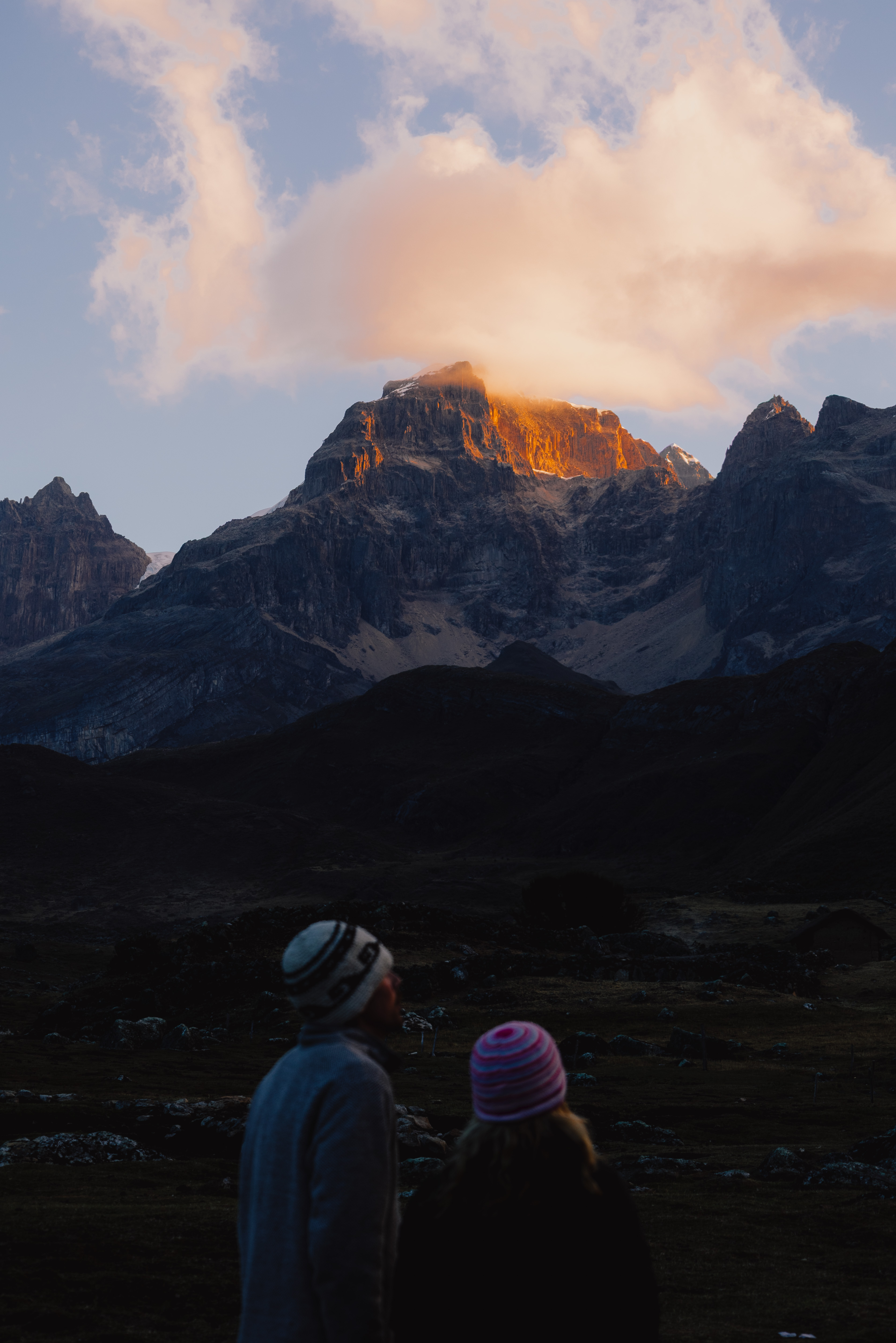 Huayhuash – goldenes Abendlicht auf einem Gipfel, zwei Silhouetten im Vordergrund