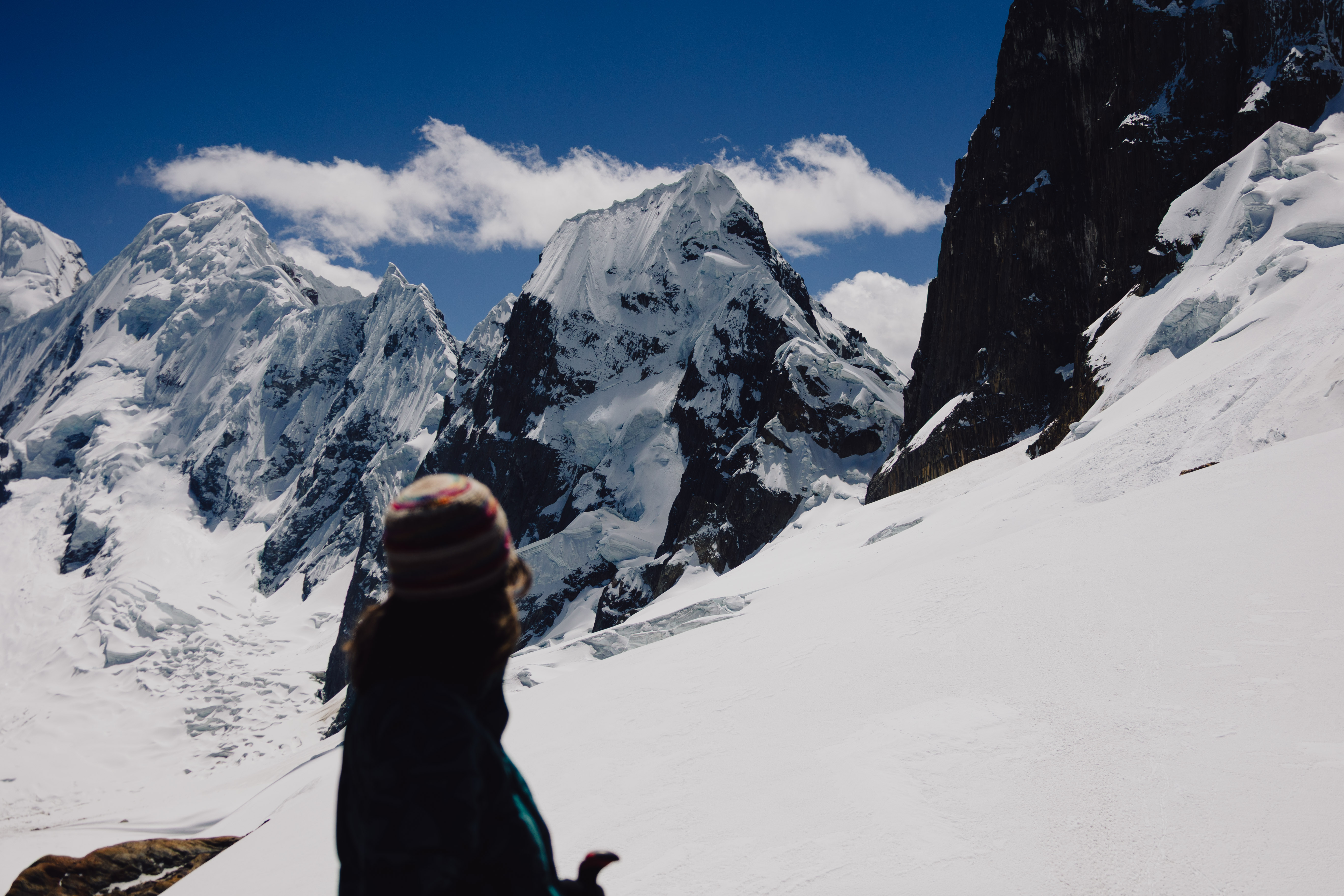 Huayhuash – Person blickt über ein Schneefeld auf die Gipfel